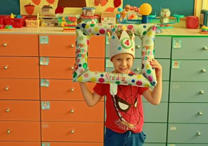 Stasiu w koronie trzyma ramkę do zdjęć.