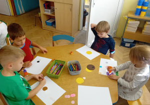 Dzieci z niebieskiego stolika przygotowują pracę plastyczną