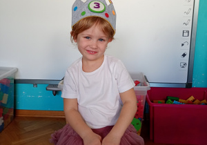 Nasza solenizanta Jagfna z koroną na głowie z cyfrą 3. W rękach trzyma torebkę w kolorowe serduszka.