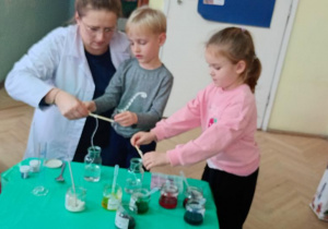 Julek i Mariia wykonują eksperyment z kryształkami soli.