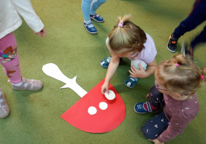 Dziewczynka układa kropki na muchomorze