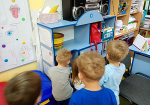 Dzieci szukają w sali zgubionych kropek muchomora