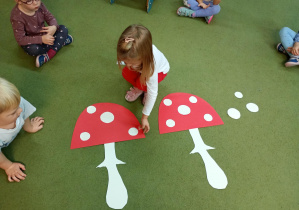 Dziewczynka odtwarza wzór z kropek na kapeluszu muchomora