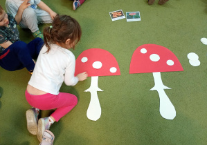 Dziewczynka odtwarza wzór z kropek na kapeluszu muchomora