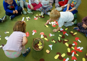 Dzieci wrzucają do koszyczka sylwety jadalnych grzybów