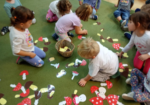 Maluchy wrzucają do koszyczka sylwety jadalnych grzybów