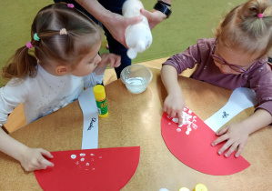 Dziewczynki palcami umoczonymi w białej farbie tworzą kropki na kapeluszu muchomora