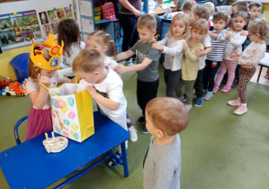 Chłopczyk częstuje się urodzinowym cukierkiem od koleżanki