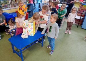 Dziewczynka częstuje się urodzinowym cukierkiem od koleżanki