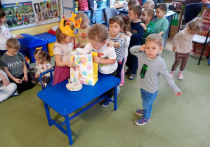 Chłopiec częstuje się urodzinowym cukierkiem od koleżanki