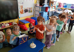 Chłopiec częstuje się urodzinowym cukierkiem od kolegi