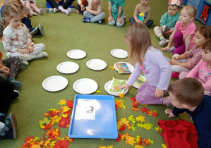 Dziewczynka kładzie na talerzyku obrazek z jednym z przysmaków jeża