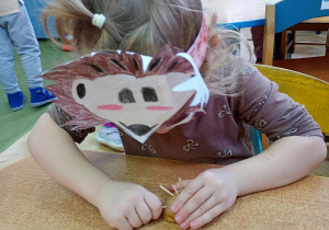 Dziewczynka tworzy jeża z ziemniaka i wykałaczek