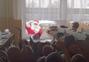 Dzieci widzą za oknem Świętego Mikołaja