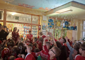 Dzieci chwytają wirujące w powietrzu mydlane bańki