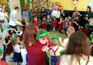 Dzieci tańczą z rodzicami do świątecznej posenki