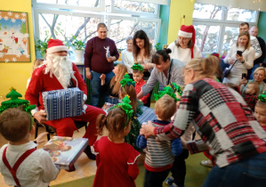 Święty Mikołaj rozdaje dzieciom prezenty