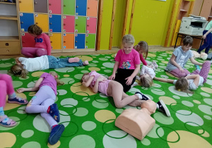 Dziewczynki ćwiczą w parach pozycję boczną ustaloną