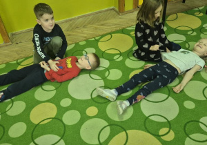 dzieci ćwiczą między sobą pozycję bezpieczną