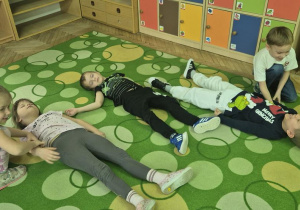 dzieci ćwiczą między sobą pozycję bezpieczną