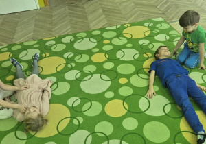 dzieci ćwiczą między sobą pozycję bezpieczną