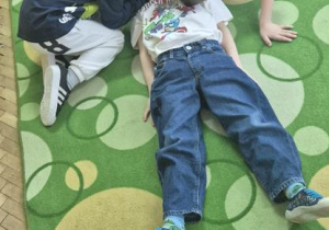 dzieci ćwiczą między sobą pozycję bezpieczną