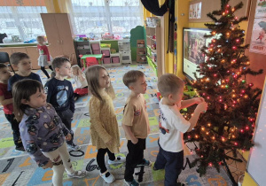 dzieci ubierają wspólnie choinkę