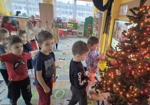 dzieci ubierają wspólnie choinkę