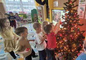 dzieci ubierają wspólnie choinkę