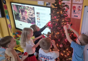 dzieci ubierają wspólnie choinkę