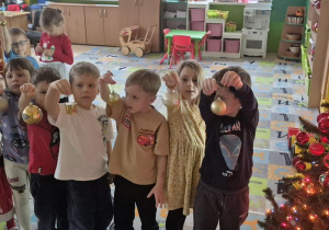 dzieci ubierają wspólnie choinkę