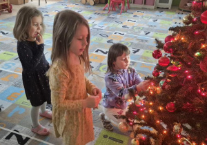 dzieci ubierają wspólnie choinkę