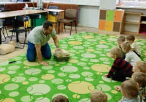 pan ratownik pokazuje dzieciom fantoma do nauki pierwszej pomocy