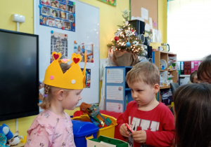 Chłopczyk częstuje się urodzinowym cukierkiem od dziewczynki