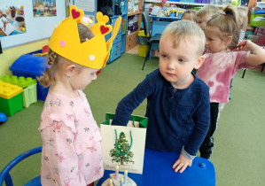 Chłopczyk częstuje się urodzinowym cukierkiem od dziewczynki