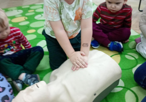 Chłopiec uczy się wykonywać masaż serca na fantomie
