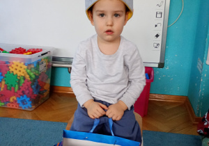 Nasz solenizant siedzi na krześle w koronie na głowie z cyfrą 3