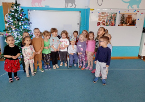 Wspólne zdjęcie solenizanta z dziećmi. W te choinka