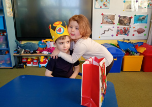 Dziewczynka przytula kolegę w dniu jego urodzin