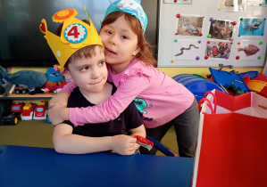 Dziewczynka przytula kolegę w dniu jego urodzin