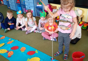 Dziewczynka złowiła na wędkę papierową sylwetę ryby