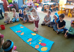 Dziewczynka łowi na wędkę papierową sylwetę ryby