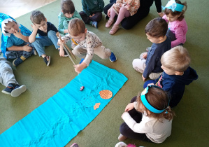 Chłopiec łowi na wędkę papierową sylwetę ryby