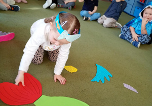 Dziewczynka składa z części sylwetę ryby