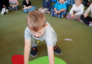 Chłopiec składa z części sylwetę ryby