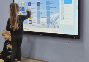 Dziewczynka dopasowuje obrazek do odpowiedniej nazwy