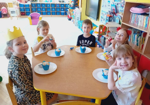 Dzieci ze stolika żółtego zjadają babeczki