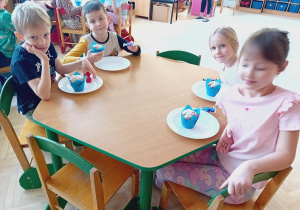 Dzieci ze stolika zielonego zjadają babeczki