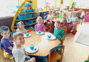 Dzieci ze stolika niebieskiego i czerwonego zjadają babeczki
