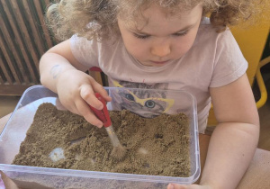 dzieci szukają szczątek diznoazura w piasku